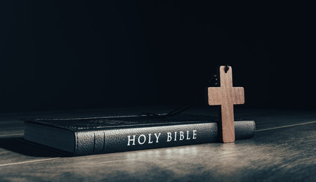 Holy Bible and wooden cross on tableの写真素材