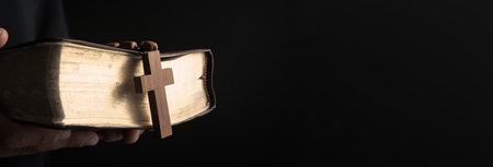 prayer man holding Holy Bilbe with cross