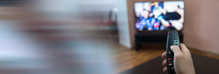 young man watching TV and use remote controllerの写真素材