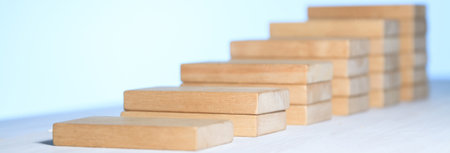 Closeup of businessman building, wooden blocks on table