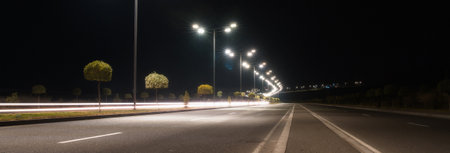 empty asphalt road and cityscape at nightの写真素材