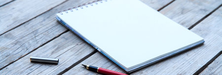 Open Blank Page notebook and pen on a rustic wooden desk.