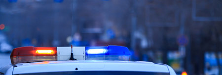 Police patrol car with flashing lights and siren on during the nightの写真素材