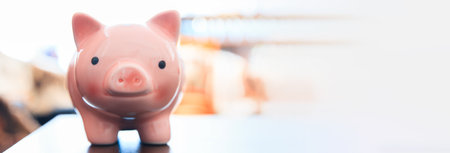 Close-up view of pink ceramic piggy bank on wooden table top.の写真素材