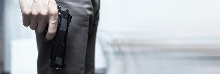 Close up of man holding hand gun.