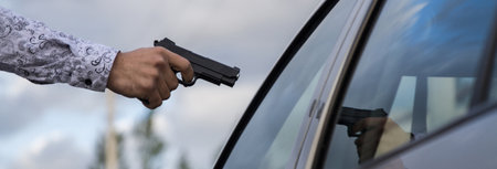 Hand points the gun on car