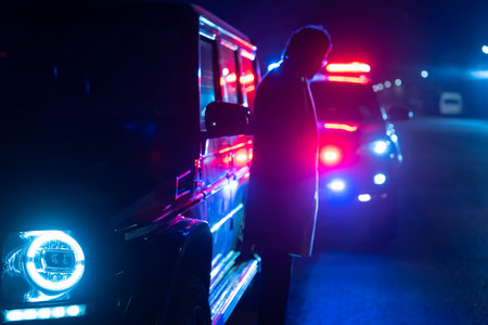 police officer stands next to a car he pulled over for speeding, reaching for the driver's ID, stock photoの写真素材