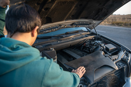 the man has opened the hood of his damaged car and is checking it. stock photoの写真素材