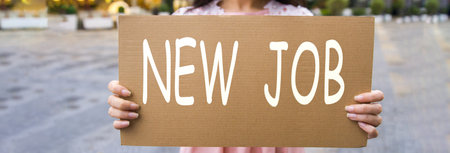 Young woman holding a new job sign.の写真素材