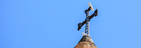 Orthodox church domed roof with a dove over the cross at blue sky.の写真素材