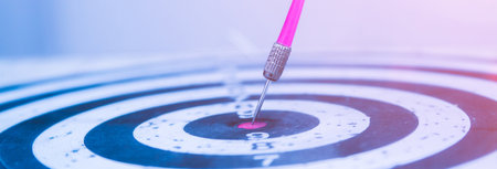 Target dart with pink arrow hitting the center, target marketing or target arrow or target business concept.の写真素材