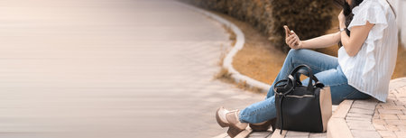 A fashionable girl sitting and staring at her phone