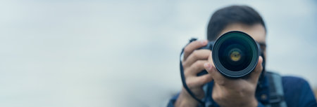Male photographer with a large professional cameraの写真素材