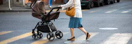 Woman with baby carriage crossing the street at a crosswalk.