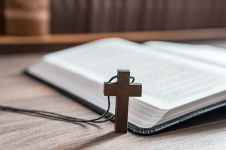 Wooden cross necklace next to open bible, Christian concept, religious symbol