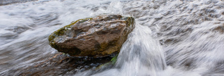 water descending the waterfall hits the stone during the dayの写真素材