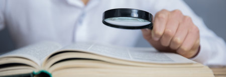 man hand magnifier on bookの写真素材
