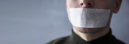 man with duct tape on mouth to prevent him from speakingの写真素材