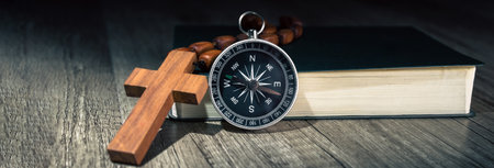 Book, cross and compass on the table. Worldview direction concept