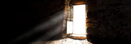 Light enters through the door of an old building during the dayの写真素材