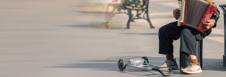 Street musician plays accordion and asks for moneyの写真素材