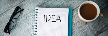 idea text on notepad with cup of coffee on tableの写真素材