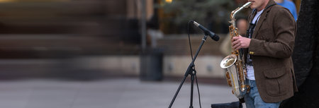 Street musician playing saxophone in the evening