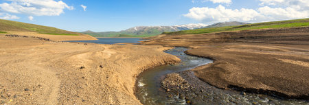 Narrow river flows into the lake during the day