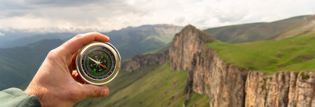 On the ground a compass with a view of the mountain during the day