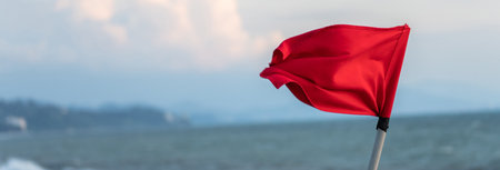 Red flag by the sea in the eveningの写真素材
