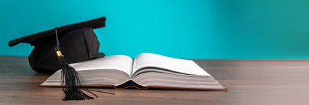 Student's hat on the book on the tableの写真素材