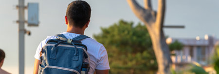 A man walks with a backpack during sunsetの写真素材