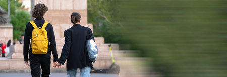 A young couple walks through the city holding handsの写真素材
