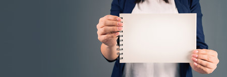 Woman holding blank notepad on gray backgroundの写真素材