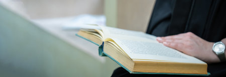 female student reading a book indoors