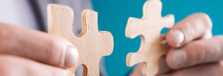Man in suit holding puzzle pieces