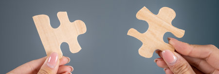 Woman holding puzzle pieces on gray backgroundの写真素材