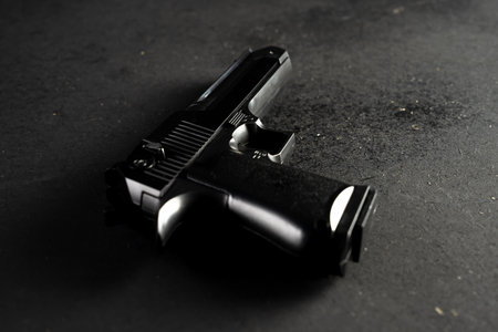 Gun on black table, criminal concept
