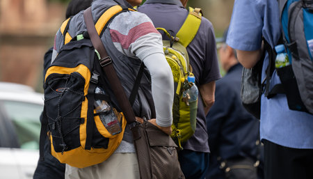 People with backpacks crossing the streetの写真素材