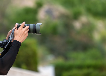 Hands of a photographer holding a cameraの写真素材