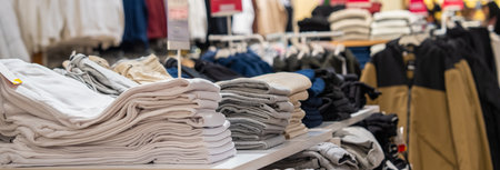 Clothing store, clothes arranged on shelvesの写真素材