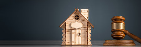 A decorative wooden house with a judge's gavel next to itの写真素材
