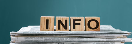 Newspapers on wooden cubes with "INFO" written on them, studio background, stock photoの写真素材