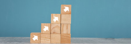 wooden block stacking as step stair on blue background. Business concept for growth success process.の写真素材