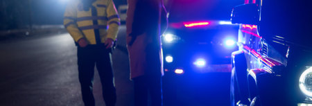 police officer stands next to a car he pulled over for speeding, reaching for the driver's ID, stock photoの写真素材