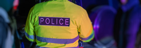 A police officer stands with his back to the car he stopped for speeding. stock photoの写真素材