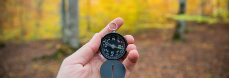 Compass in man's hand, in the autumn forestの写真素材