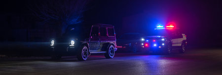 police car stands next to a car he pulled over for speeding, reaching for the driver's ID. , stock photoの写真素材