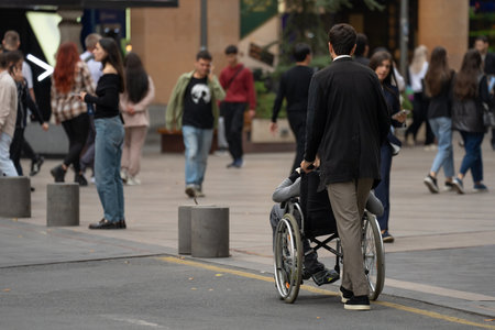A man in a wheelchair crosses the street.の写真素材
