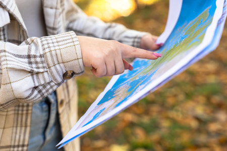 A girl tourist with a map in her hand, orienting herself in the areaの写真素材